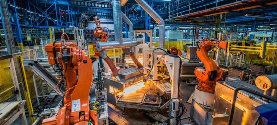 Impianto industriale automatizzato con robot e macchinari moderni che migliorano l'efficienza e la qualità della produzione.