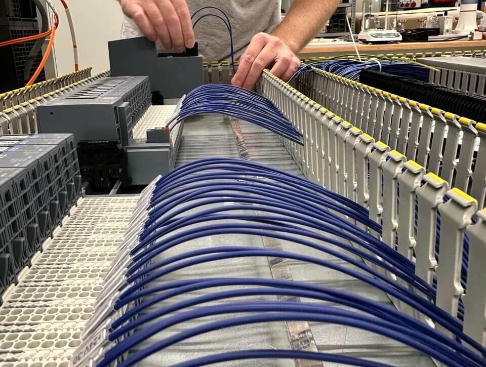 Tecnico al lavoro sul cablaggio di un quadro elettrico industriale