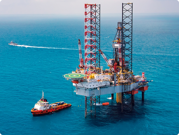 Piattaforma offshore per l'estrazione di petrolio e gas con navi di supporto circostanti, rappresentativa delle infrastrutture complesse del settore Oil & Gas oggetto del progetto ATENE per la rilevazione predittiva dei guasti