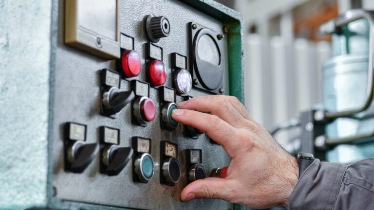 operatore davanti a un quadro di controllo di automazione industriale