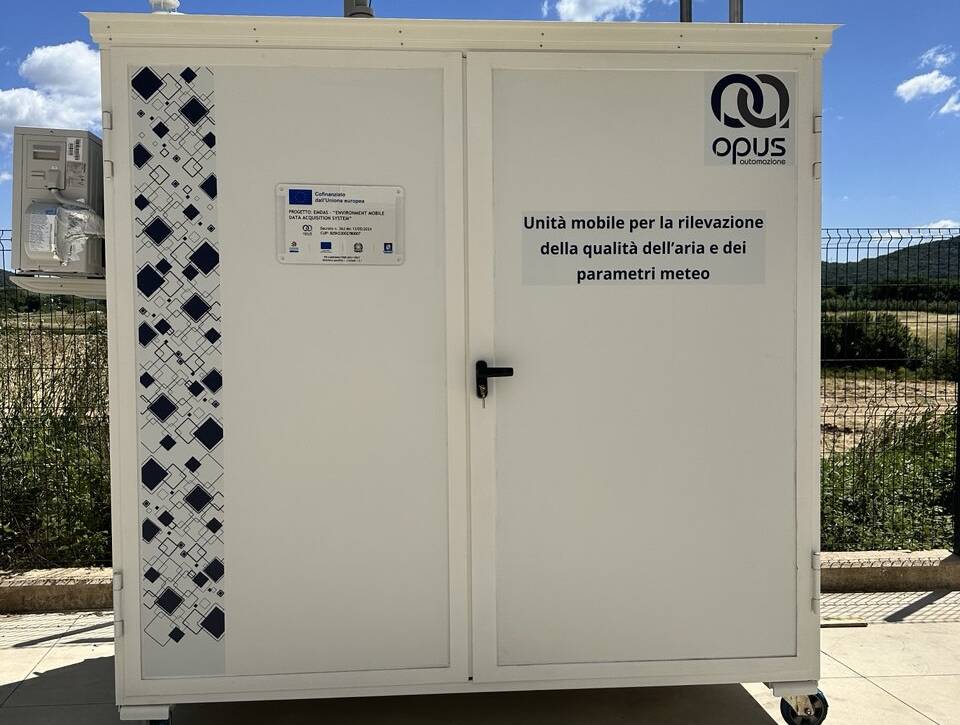 Cabina mobile bianca per il monitoraggio della qualità dell’aria e dei parametri meteo, con il logo Opus Automazione e sensori ambientali installati sul tetto.