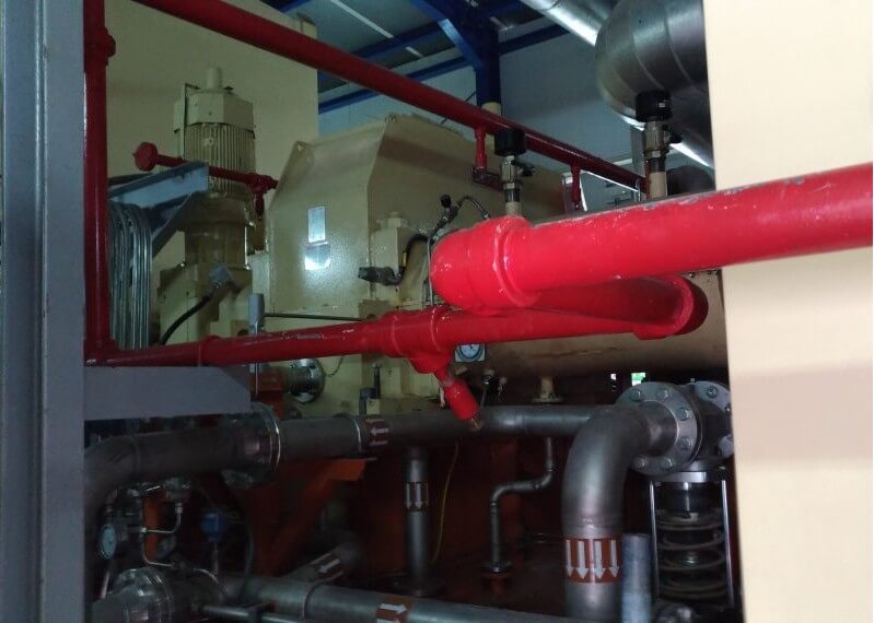 Vista di compressore industriale e tubazioni durante analisi vibrazioni treni di compressione