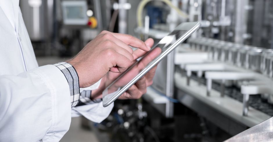Un operatore che con il tablet gestisce una linea di produzione industriale
