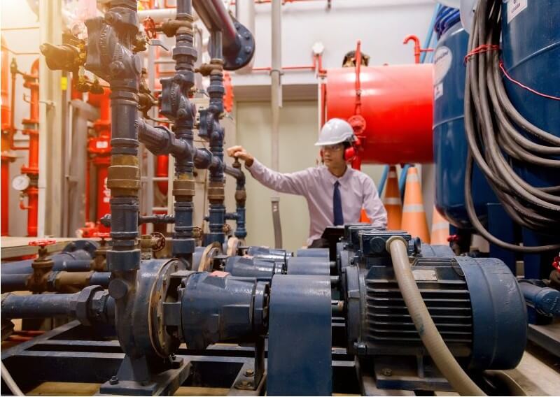 Tecnico vicino a motori industriali per monitoraggio vibrazioni manutenzione predittiva