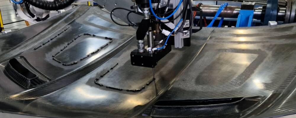 Incollaggio componenti in carbonio con braccio cobot, in assetto industriale